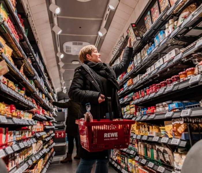 Eine Dame befindet sich gerade im REWE-Einkaufs-Bus und erledigt ihre Einkäufe. (Foto: REWE)